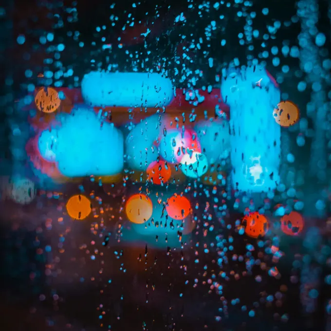 Niska jakość, zamazane zdjęcie padającym deszczem i światłami