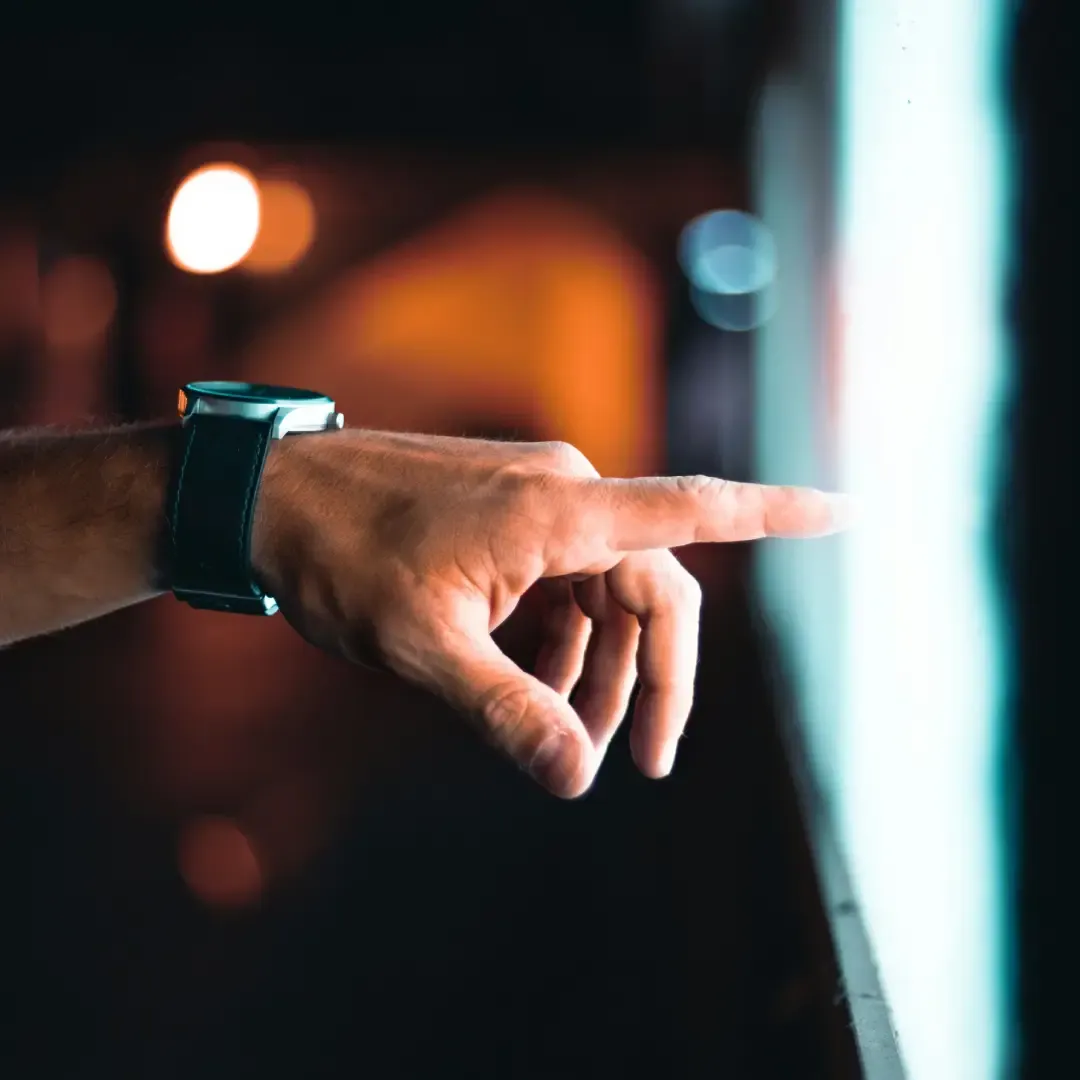 Osoba pokazuje palcem konkretne miejsce na ekranie monitora lub tablicy.